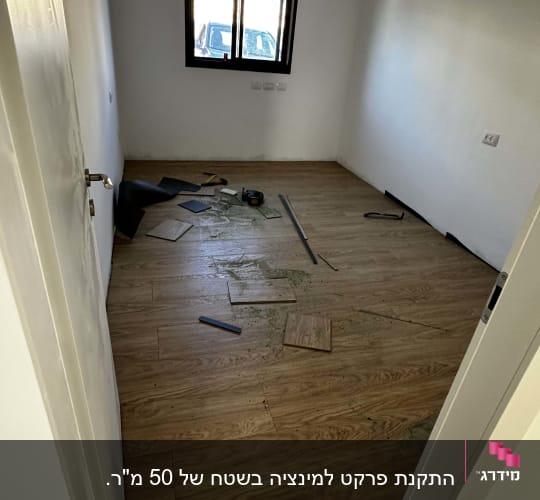 חדר עם פרקט מותקן וכלי עבודה על הרצפה